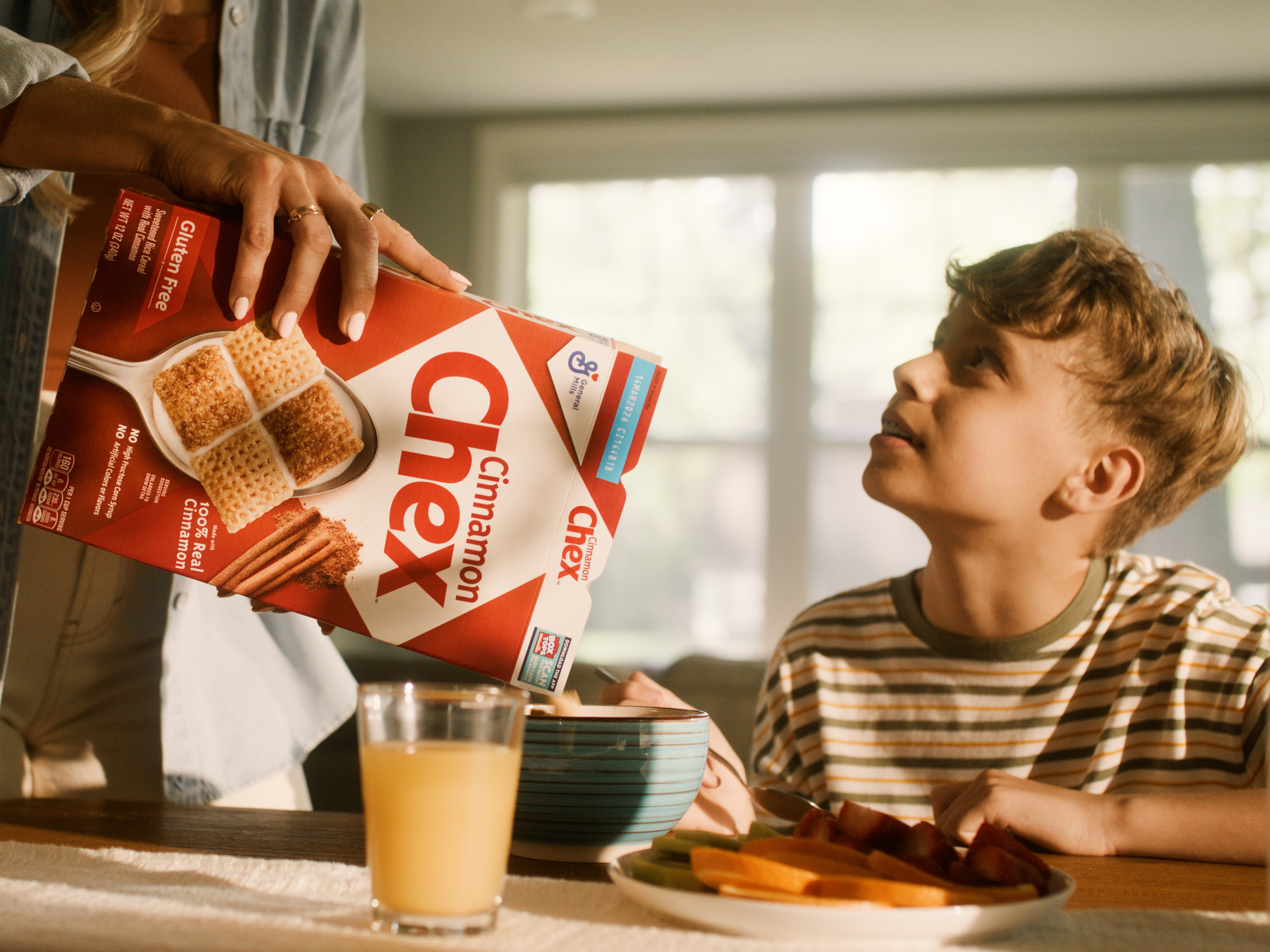Chex being poured into a bowl for a young male.