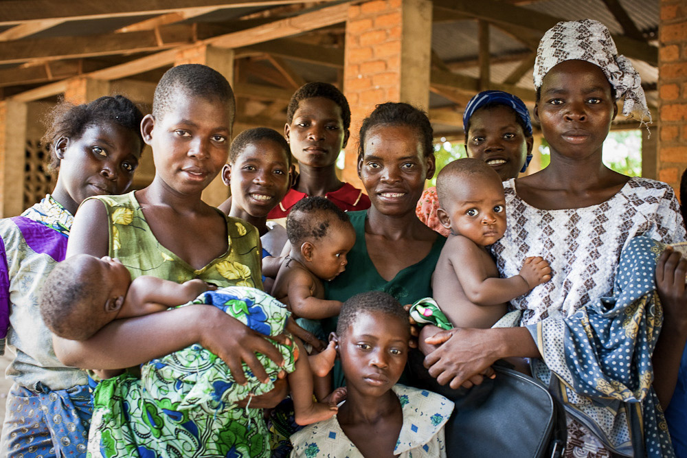 Women holding their babies and smiling.